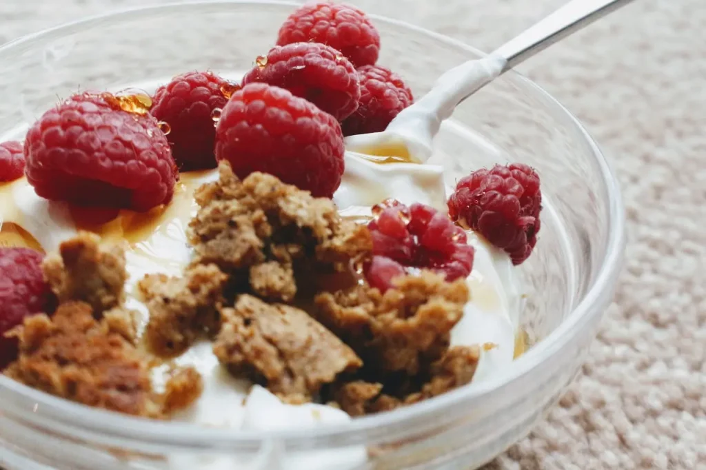 A bowl of Greek Yogurt with strawberries and spoon  